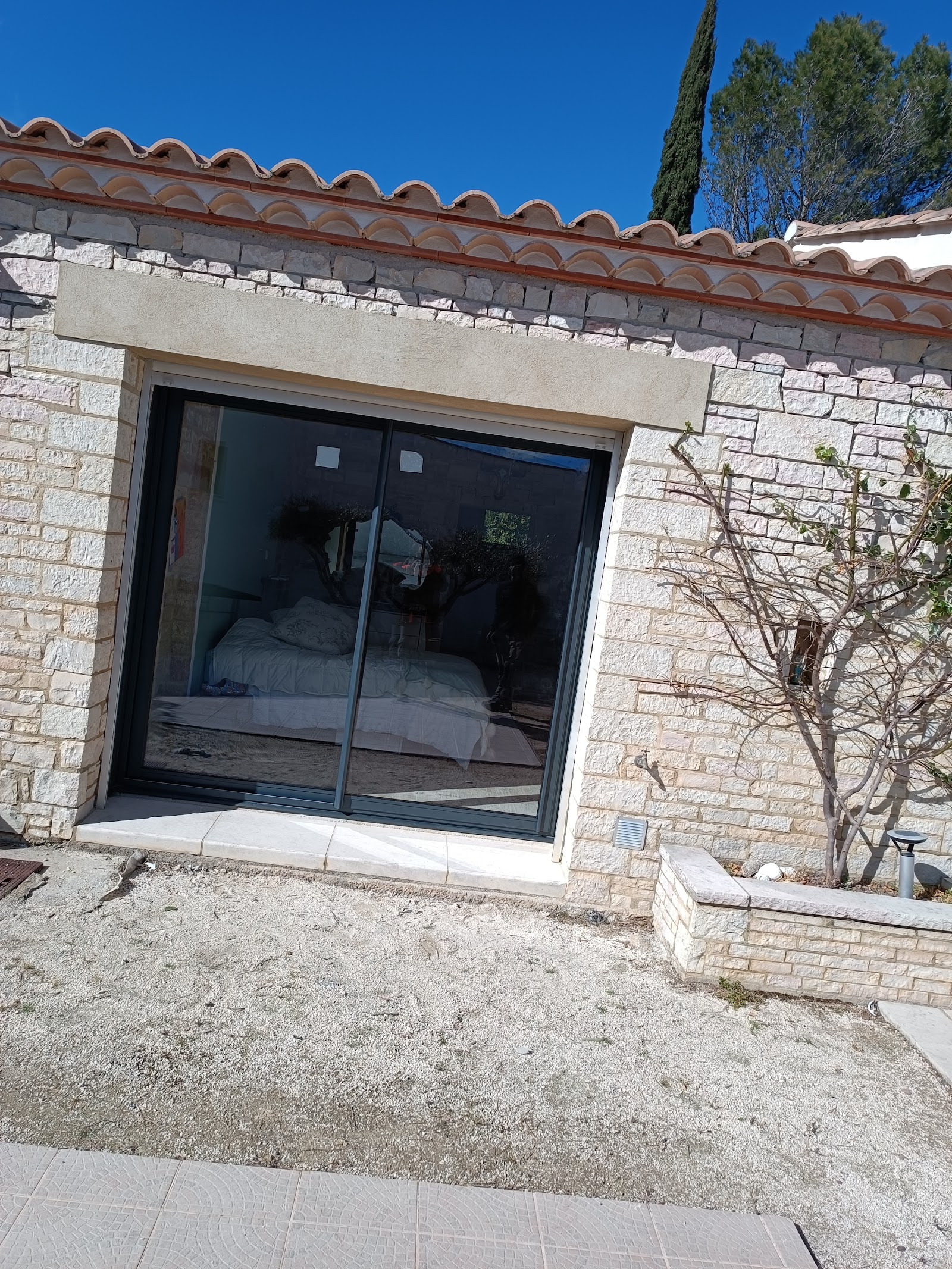 Baie coulissante aluminium anthracite posée dans un mas en pierre par RM Menuiserie