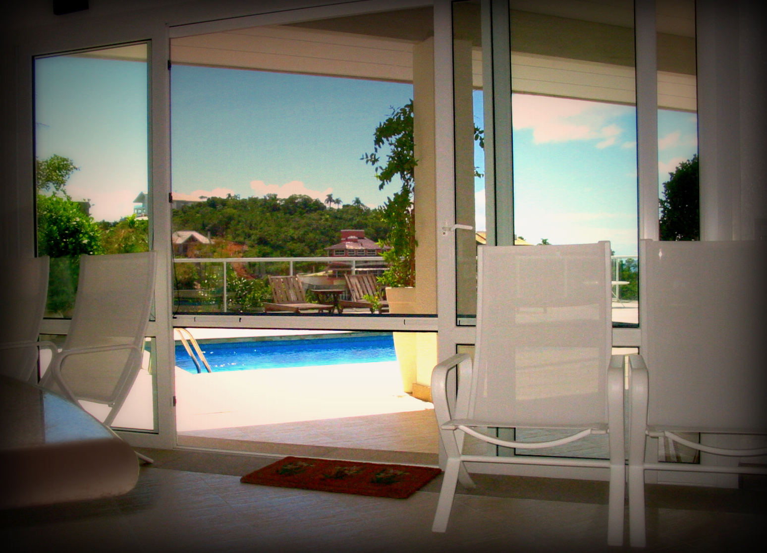 Grande ouverture vitrée donnant sur une terrasse et une piscine